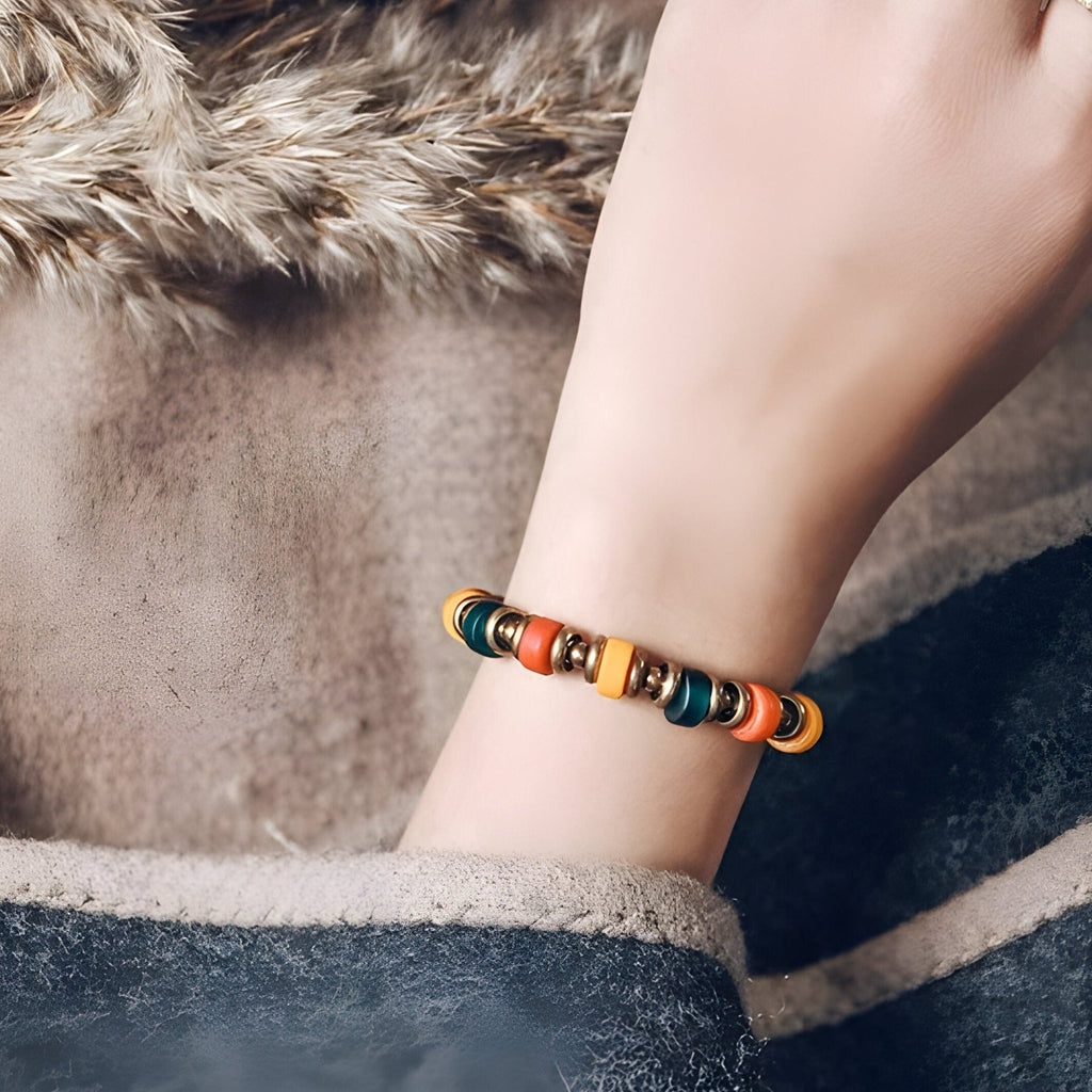 Bracelet Milenca en verre coloré multicolore avec accents cuivre sur poignet féminin.