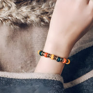 Bracelet Milenca en verre coloré multicolore avec accents cuivre sur poignet féminin.