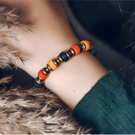 Bracelet femme en perles de verre multicolores et cuivre sur poignet, style bohème chic.