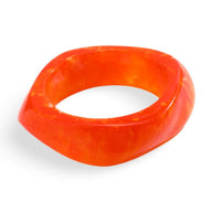 Bracelet épais en acrylique orange vif avec forme irrégulière et finition lisse.