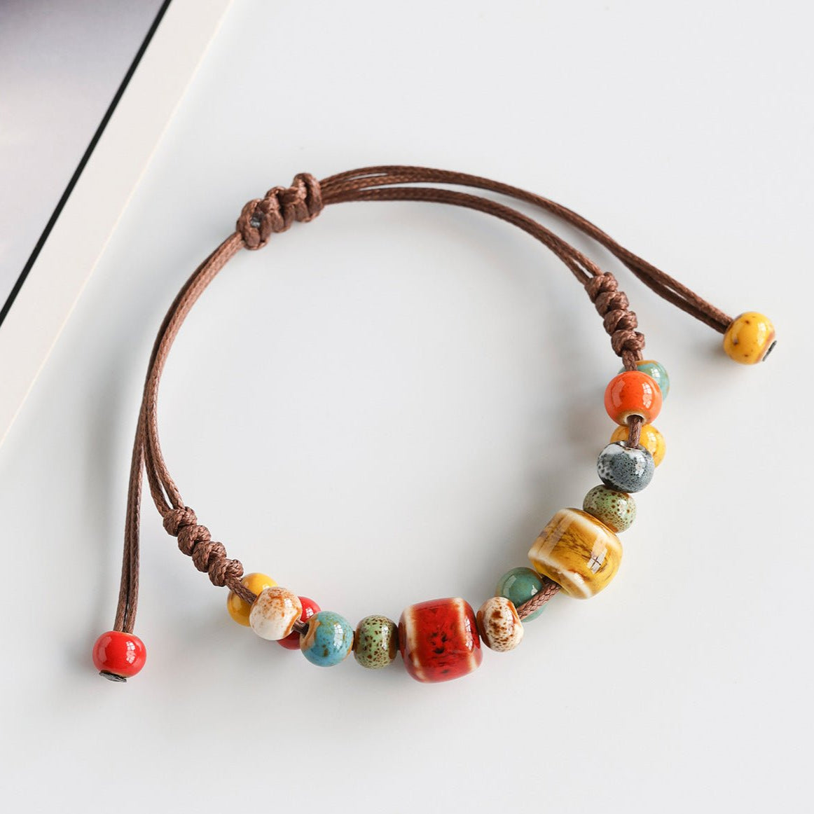 Bracelet estivale en perles de céramique, cordon ciré, formes abstraites, look moderne, modèle Saloua - La Boutique du Bracelet