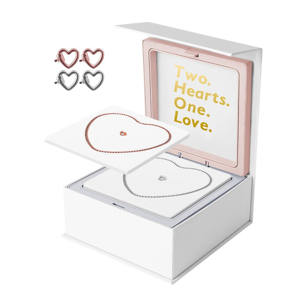 Bracelet en acier inoxydable argenté en forme de cœur dans boîte blanche avec texte doré "Two. Hearts. One. Love.".