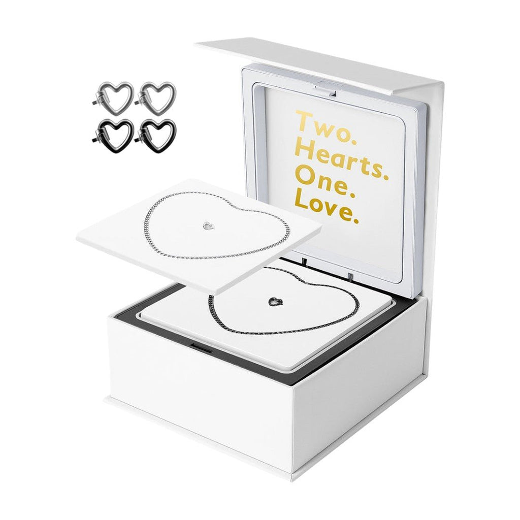 Bracelet en acier inoxydable en forme de cœur, finition argentée, présenté dans un coffret blanc avec message doré "Two.
