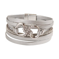 Bracelet multi-rangs argenté en simili vegan avec strass et fermoir magnétique, motif infini au centre.