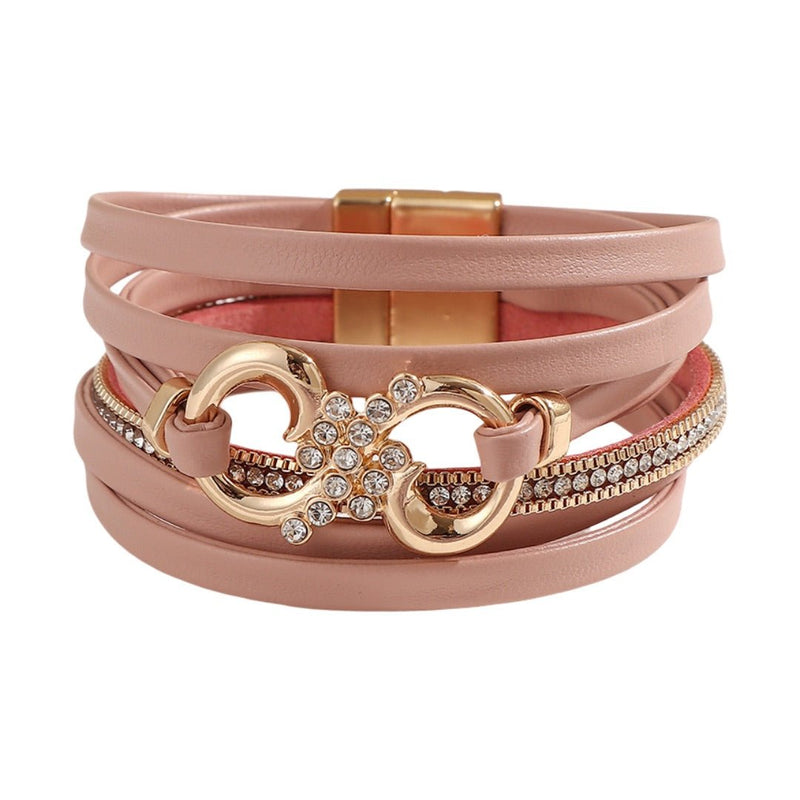 Bracelet femme multi-rangs rose poudré en simili cuir avec strass, fermoir magnétique doré, motif infini orné de cristaux.