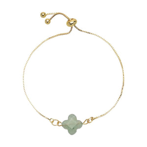Bracelet fin doré à cordon ajustable avec pierre naturelle taillée en trèfle vert pâle au centre.