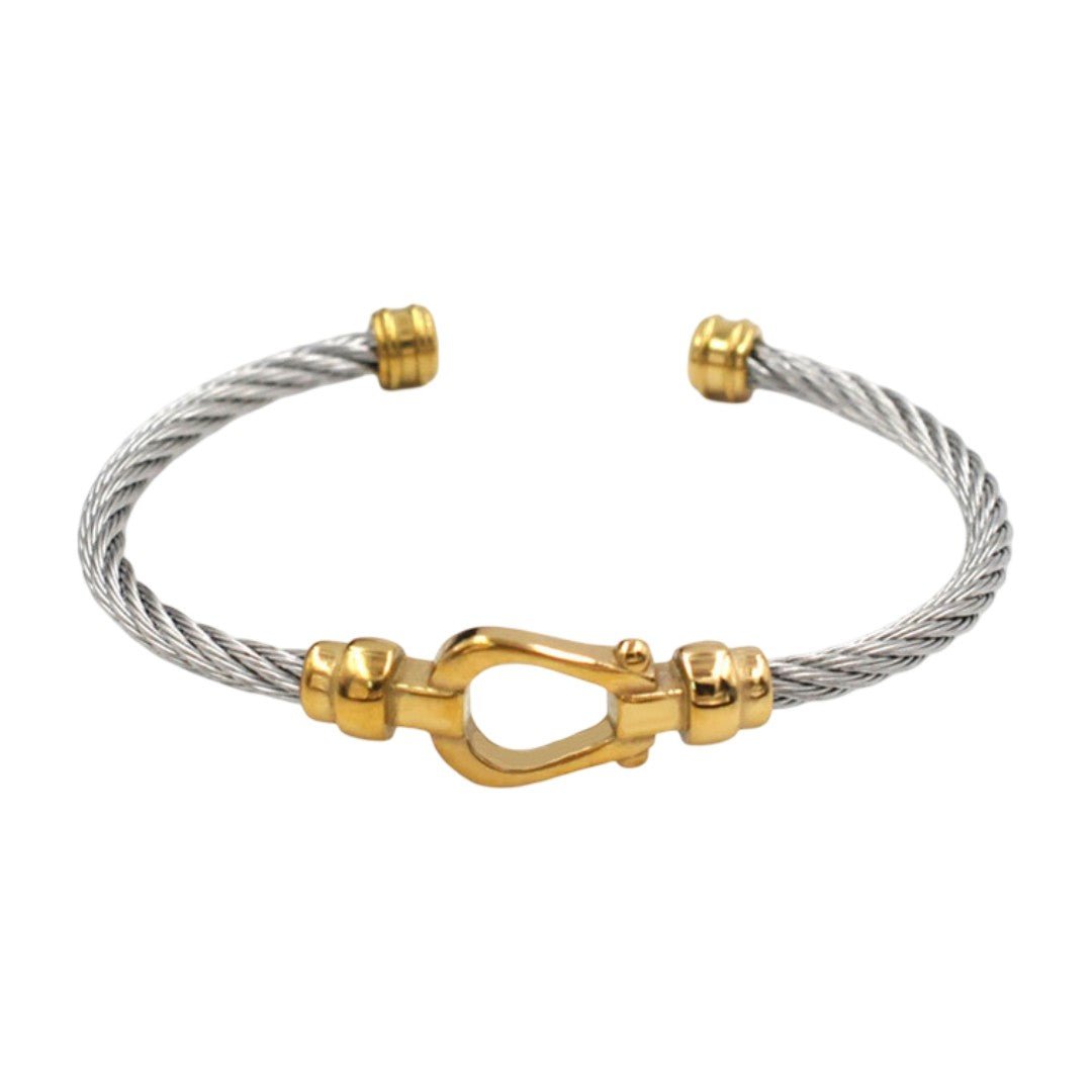 Bracelet jonc ouvert en acier inoxydable torsadé argent avec fer à cheval doré aux extrémités.