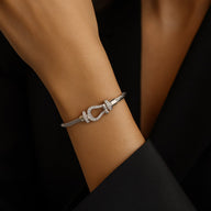 Bracelet femme cordon titane gris clair avec pendentif fer à cheval argenté élégant.