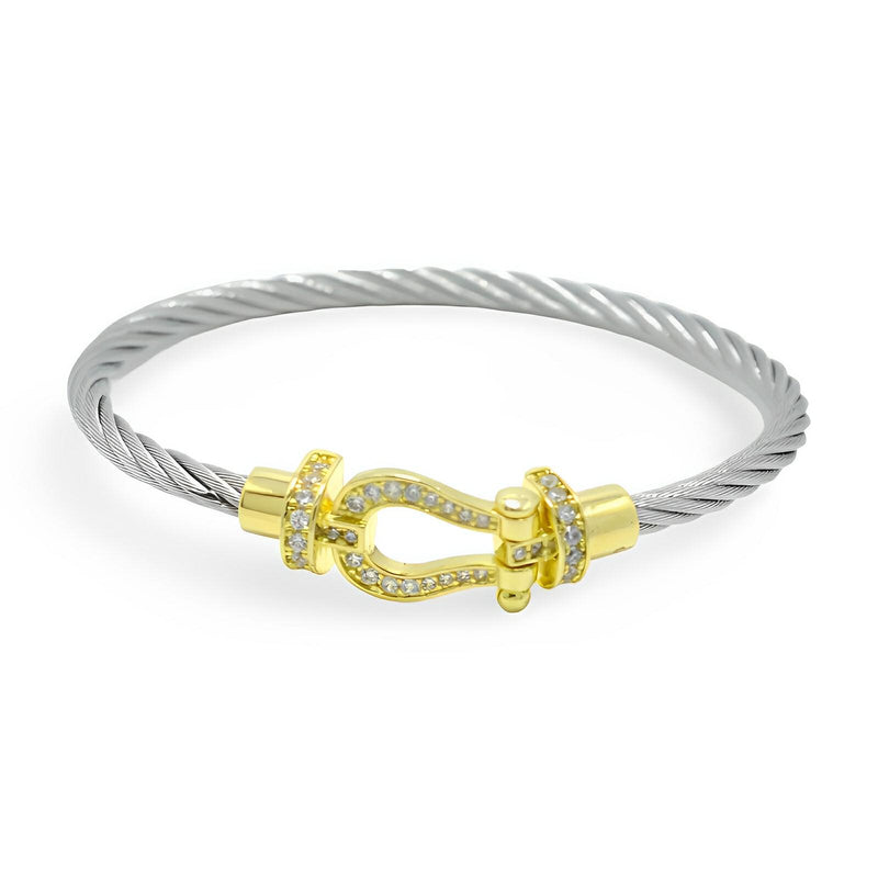 Bracelet fer à cheval en cordon titane argenté avec fermoir doré orné de cristaux blancs.