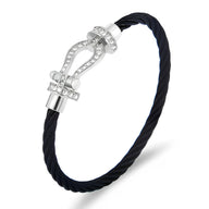 Bracelet en cordon noir torsadé avec fermoir fer à cheval en titane argenté orné de petites pierres brillantes.