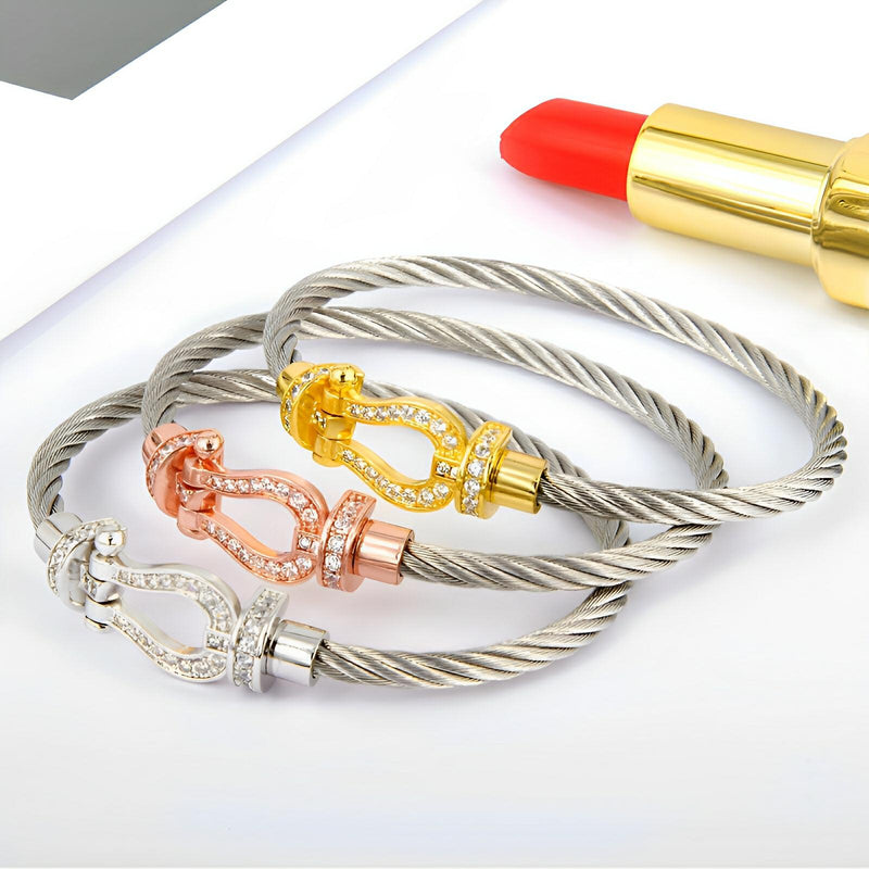 Trois bracelets fer à cheval en cordon titane, finitions argent, or rosé et or jaune, détail clouté, style élégant féminin.