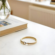 Bracelet fer à cheval en acier inoxydable doré tressé avec fermoir anneau, style élégant féminin.