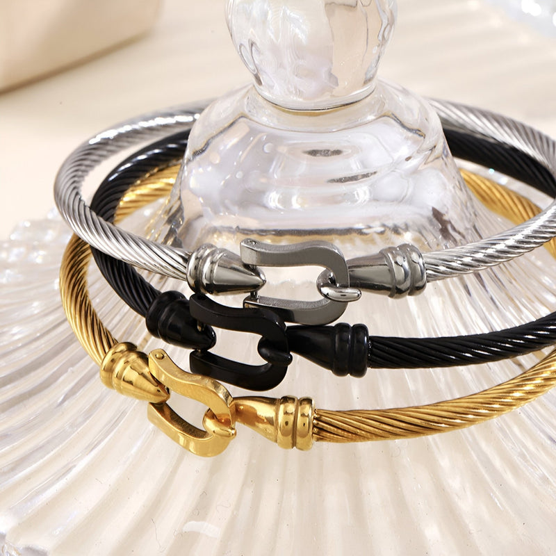 Bracelets fer à cheval en acier inoxydable torsadé, finitions or, argent et noir, fermoirs stylisés.
