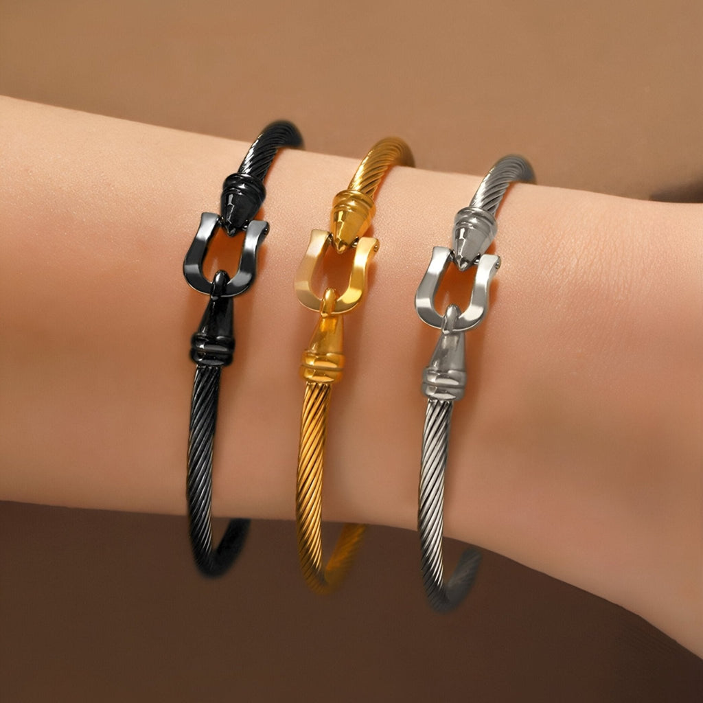 Trois bracelets fer à cheval en acier inoxydable, couleurs noir, or et argent, modèle Léandre, sur poignet.