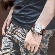 Bracelet fer à cheval or rosé en cuir marron avec détails acier inoxydable porté au poignet homme.