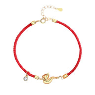 Bracelet tressé rouge avec breloque dragon dorée et pendentif cristal clair.