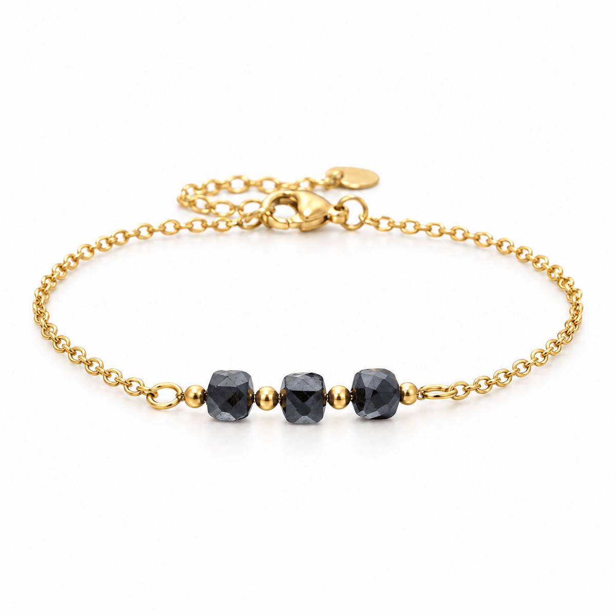 Packshot studio bracelet Bracelet fin en acier doré, maille forçat, trois pierres naturelles facettées, bijou élégant et lumineux, modèle Ilumia — Hématite, vue frontale basse, fond blanc pur, détails verrouillés