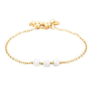 Bracelet fin en acier doré avec trois pierres semi-précieuses blanches facettées et maille forçat élégante.