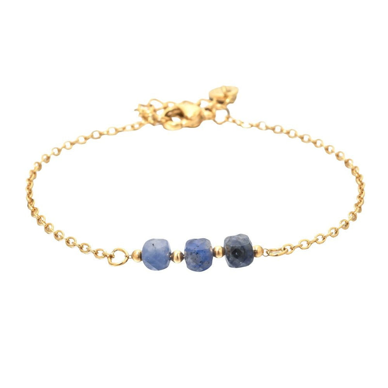 Bracelet fin en acier doré avec trois pierres semi-précieuses bleu facettées sur maille forçat délicate.