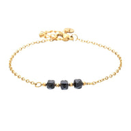 Bracelet fin en acier doré avec chaîne maille forçat et trois pierres semi-précieuses noires facettées.