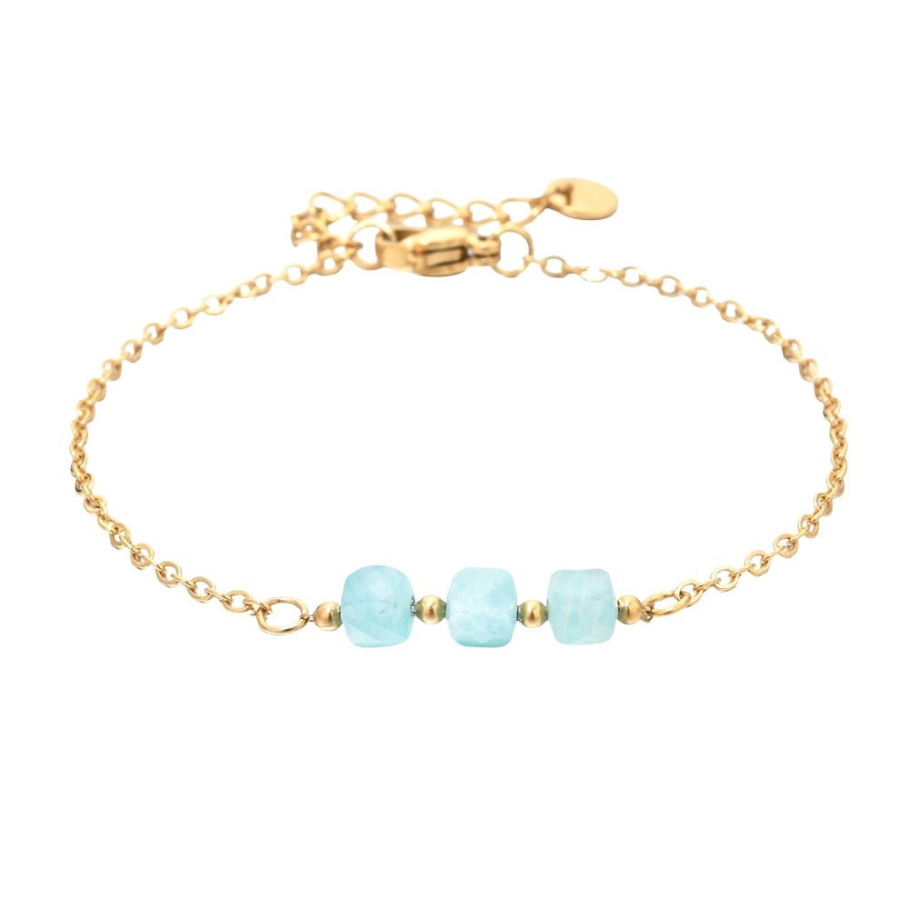 Bracelet fin en acier doré avec trois pierres semi-précieuses bleues facettées sur une maille forçat délicate.