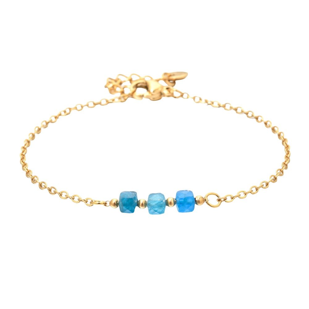Bracelet fin en acier doré avec trois perles semi-précieuses facettées bleues sur maille forçat délicate.