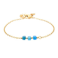 Bracelet fin en acier doré avec trois perles semi-précieuses facettées bleues sur maille forçat délicate.