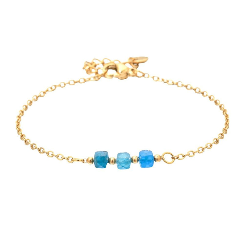 Bracelet fin en acier doré avec trois perles semi-précieuses facettées bleues sur maille forçat délicate.