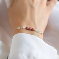 Bracelet fin pour femme en pierres naturelles rose et blanches, chaîne délicate en métal doré.