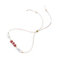 Bracelet fin rose en pierres naturelles avec perles dorées, style délicat et élégant.