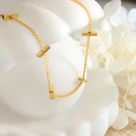 Bracelet fin en titane plaqué or avec petits barres rectangulaires et chaîne délicate.