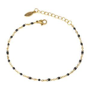 Bracelet fin doré en acier inoxydable avec maille forçat et perles noires, fermoir mousqueton réglable.