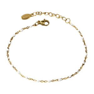 Bracelet fin doré en acier inoxydable avec maille forçat plaquée or, perles colorées et fermoir mousqueton réglable.