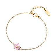 Bracelet fin en acier inoxydable avec fleur rose délicate et détails dorés.