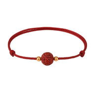Bracelet en coton fil rouge avec perle cinabre rouge gravée fleur de lotus et petites perles dorées.