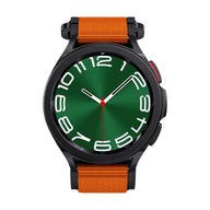 Montre noire Garmin avec bracelet orange en nylon réglable, cadran rond vert style sport outdoor.