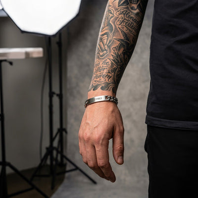 Bracelet gourmette anthracite en acier inoxydable, finition mate, style mixte, porté au poignet.
