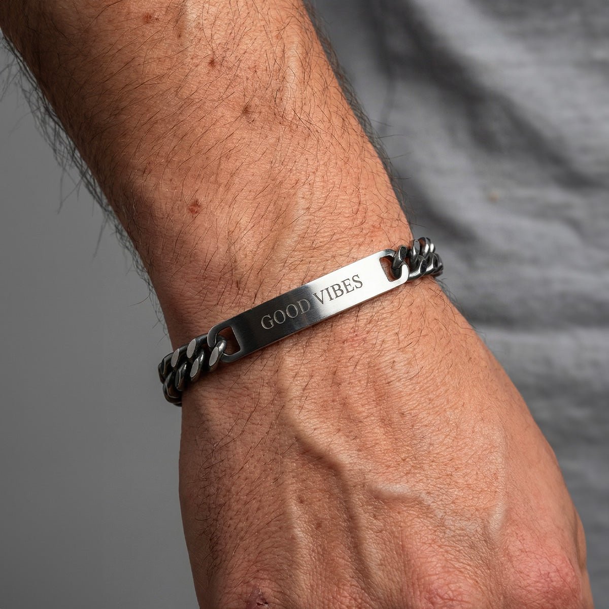Bracelet gourmette anthracite en acier inoxydable avec plaque gravée "Good Vibes", style mixte.
