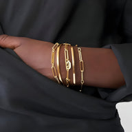 Bracelets gourmettes dorés à deux plaques en acier inoxydable, maillons larges rectangulaires, porté femme.