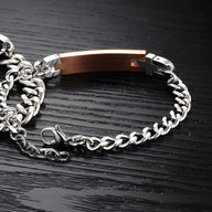Bracelet gourmette féminin en acier inoxydable rose avec plaque lisse et chaîne argentée fine.