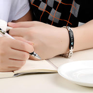 Bracelet gourmette homme en acier inoxydable noir avec plaque gravée et pierre de zirconium.