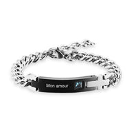 Bracelet gourmette argenté en acier inoxydable avec plaque personnalisée noire et pierre de zirconium bleue.