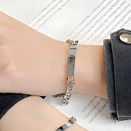 Bracelet gourmette en acier inoxydable argenté à maille cubaine avec plaque personnalisée sur poignet mixte.