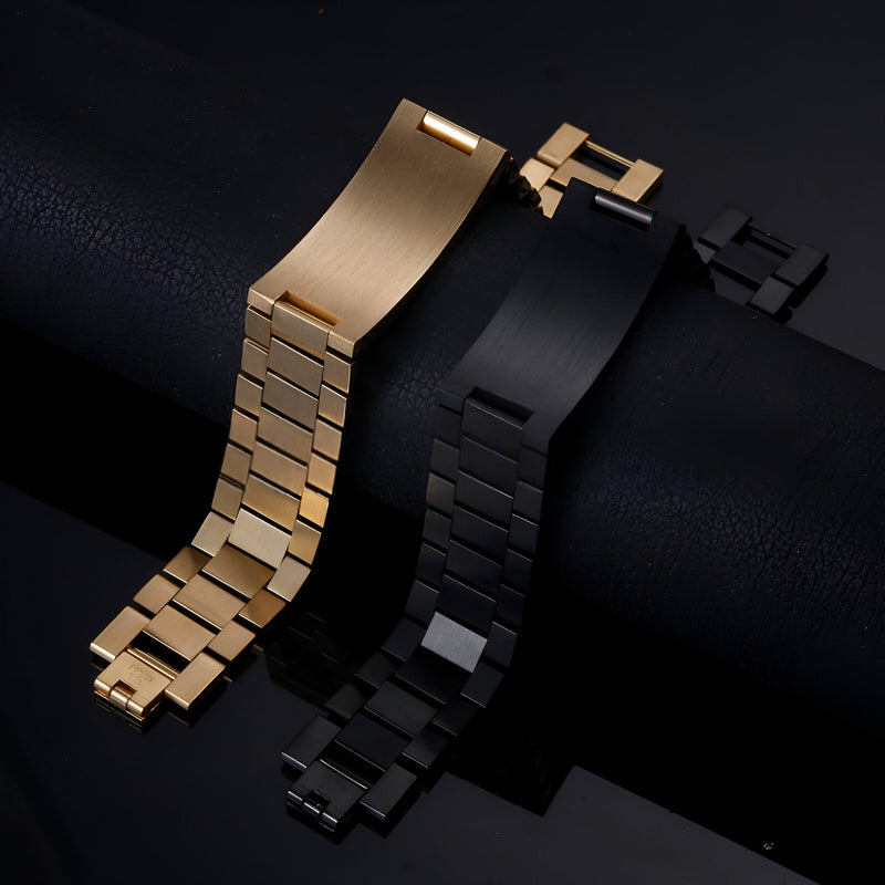 Bracelet gourmette en acier inoxydable or, maille épaisse, fermoir rectangulaire et bracelet noir mat similaire posé côte à.