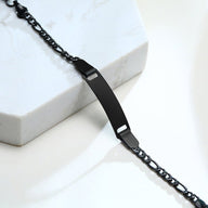 Bracelet gourmette noir en acier inoxydable avec plaque lisse et maille figaro fine.