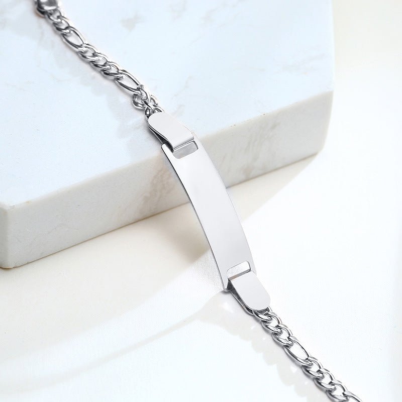 Bracelet gourmette en acier inoxydable argent avec maille figaro et plaque personnalisable.