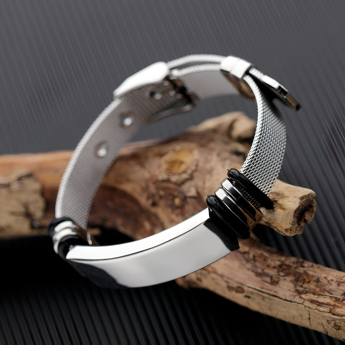 Bracelet gourmette pour homme en acier inoxydable argenté, maille milanaise fine avec plaque lisse et détails noirs.