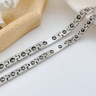 Bracelet gourmette mixte en acier inoxydable argenté avec maillons rectangulaires ajourés et ronds.