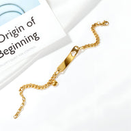 Bracelet gourmette en acier inoxydable doré avec plaque fine et motif cœur découpé.