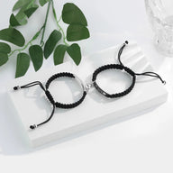 Paire de bracelets gourmette en acier inoxydable, l'un argenté, l'autre noir, avec cordon tressé réglable.